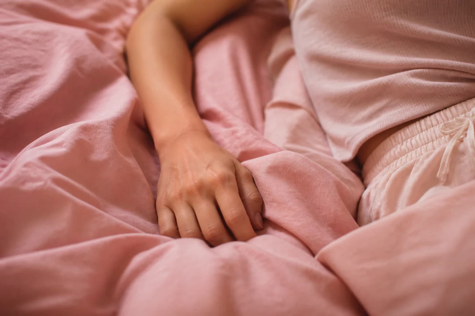 Ontspannen hand rust in zacht bloesemroze beddengoed