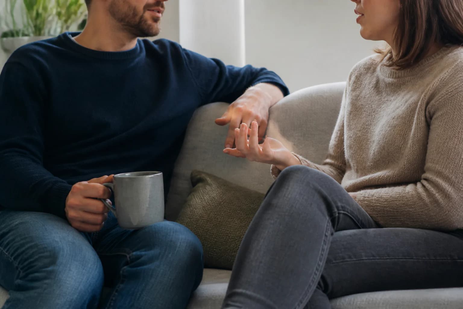 Twee mensen voeren in helder middaglicht een rustig gesprek op de bank